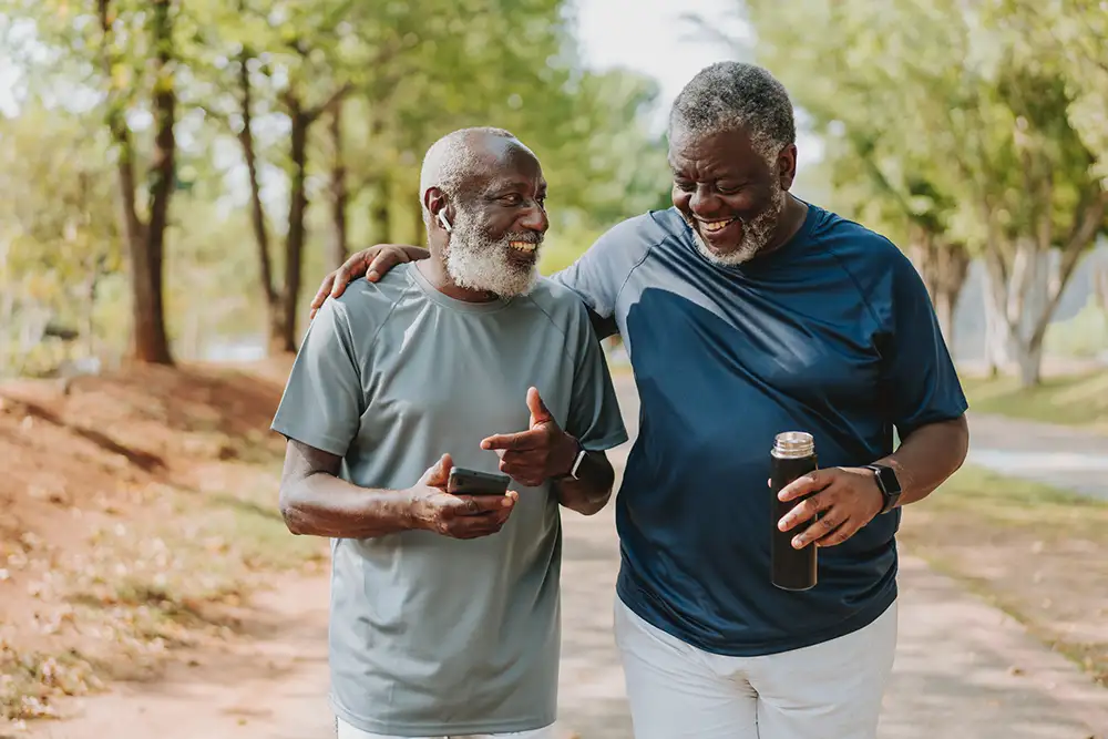 Two older men walking on a trail together