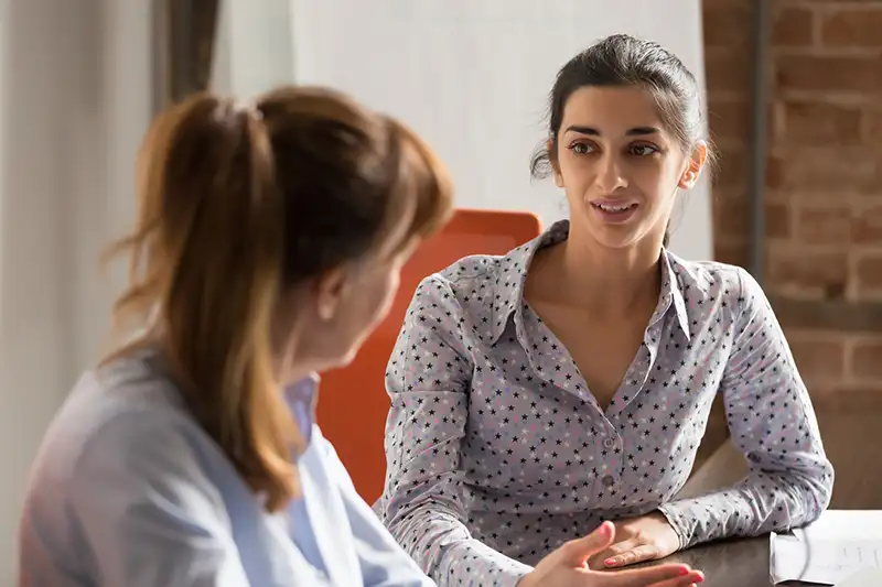 Two women talking to each other in an office