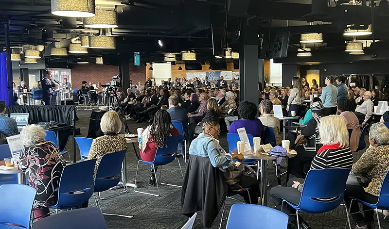 LGH group at an event listening to a speaker